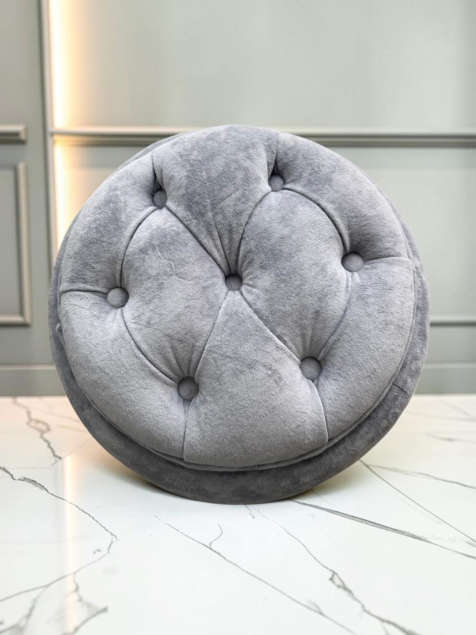 Banco Leisecester de CASA GARRIDO Muebles, taburete redondo gris capitoneado con tapizado suave y elegante