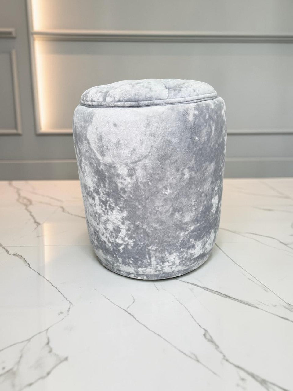 Banco Leisecester de CASA GARRIDO Muebles, taburete redondo gris capitoneado con tapizado de terciopelo suave.