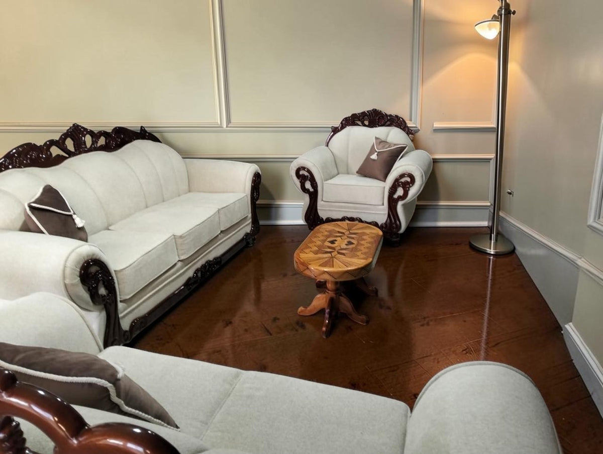Juego de sala CASA GARRIDO Muebles con sofás tapizados en crema y detalles de madera tallada oscura en estilo clásico.
