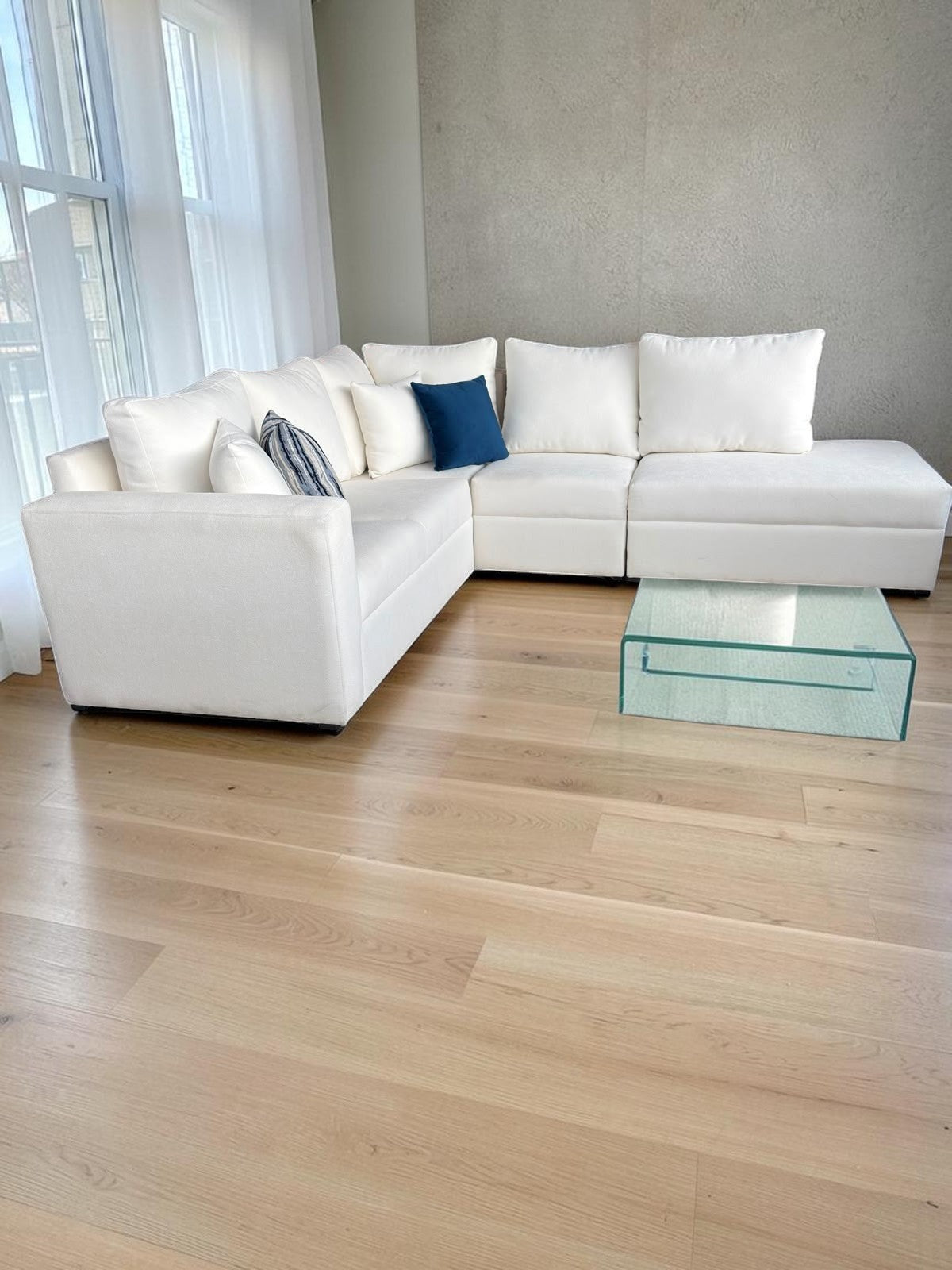 Sala modular blanca CASA GARRIDO Muebles con diseño seccional versátil, cojines decorativos y mesa de centro de cristal