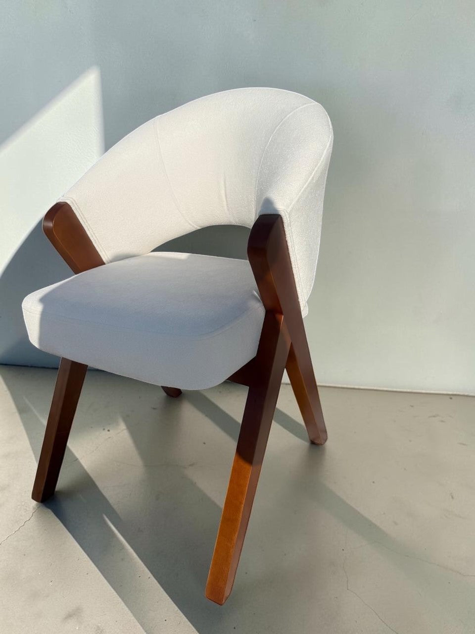 Silla Berlin de CASA GARRIDO Muebles con estructura de madera maciza y tapizado blanco en asiento y respaldo curvo