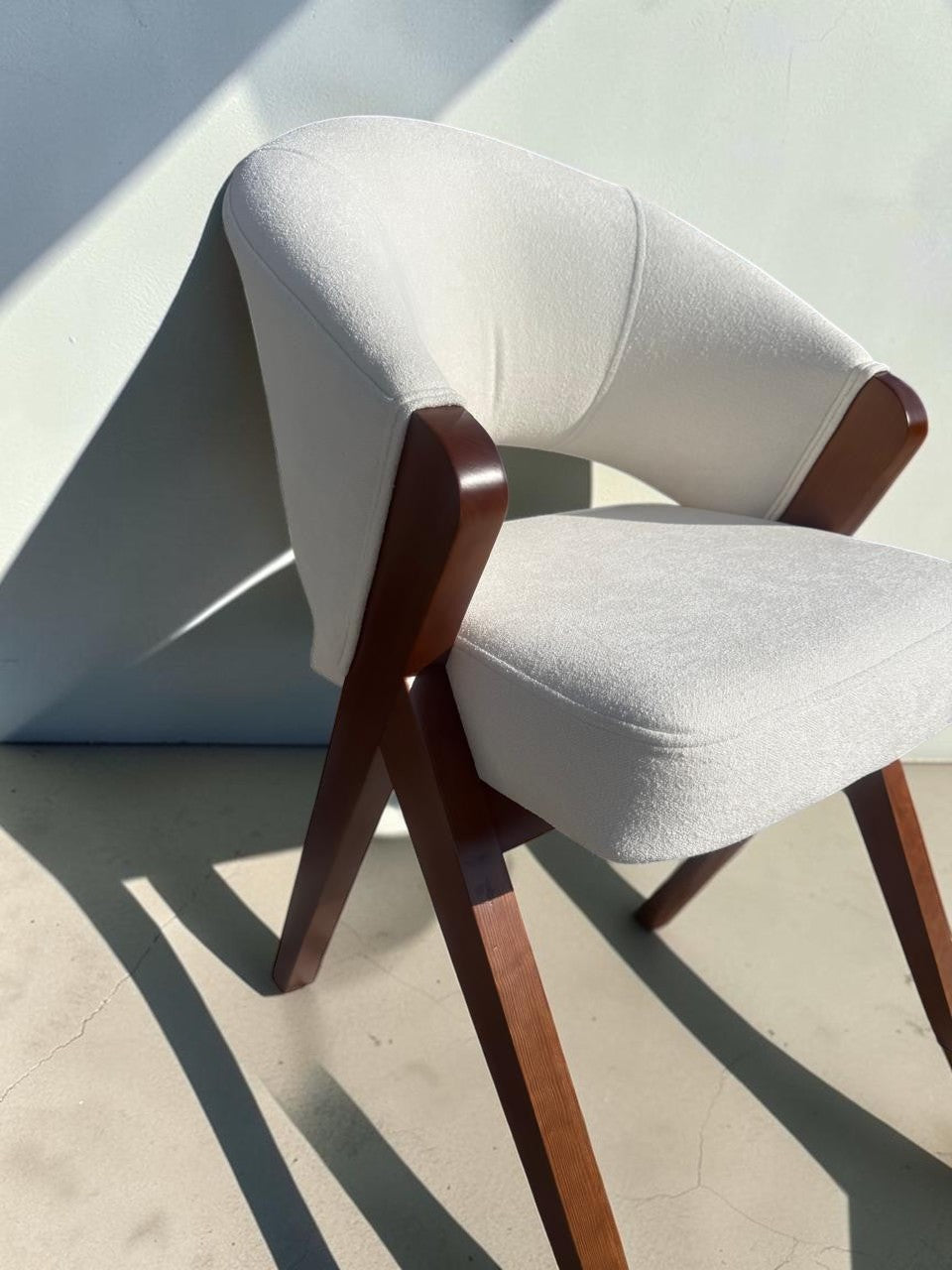Silla Berlin de CASA GARRIDO Muebles con estructura de madera oscura y tapizado en color crema de diseño moderno