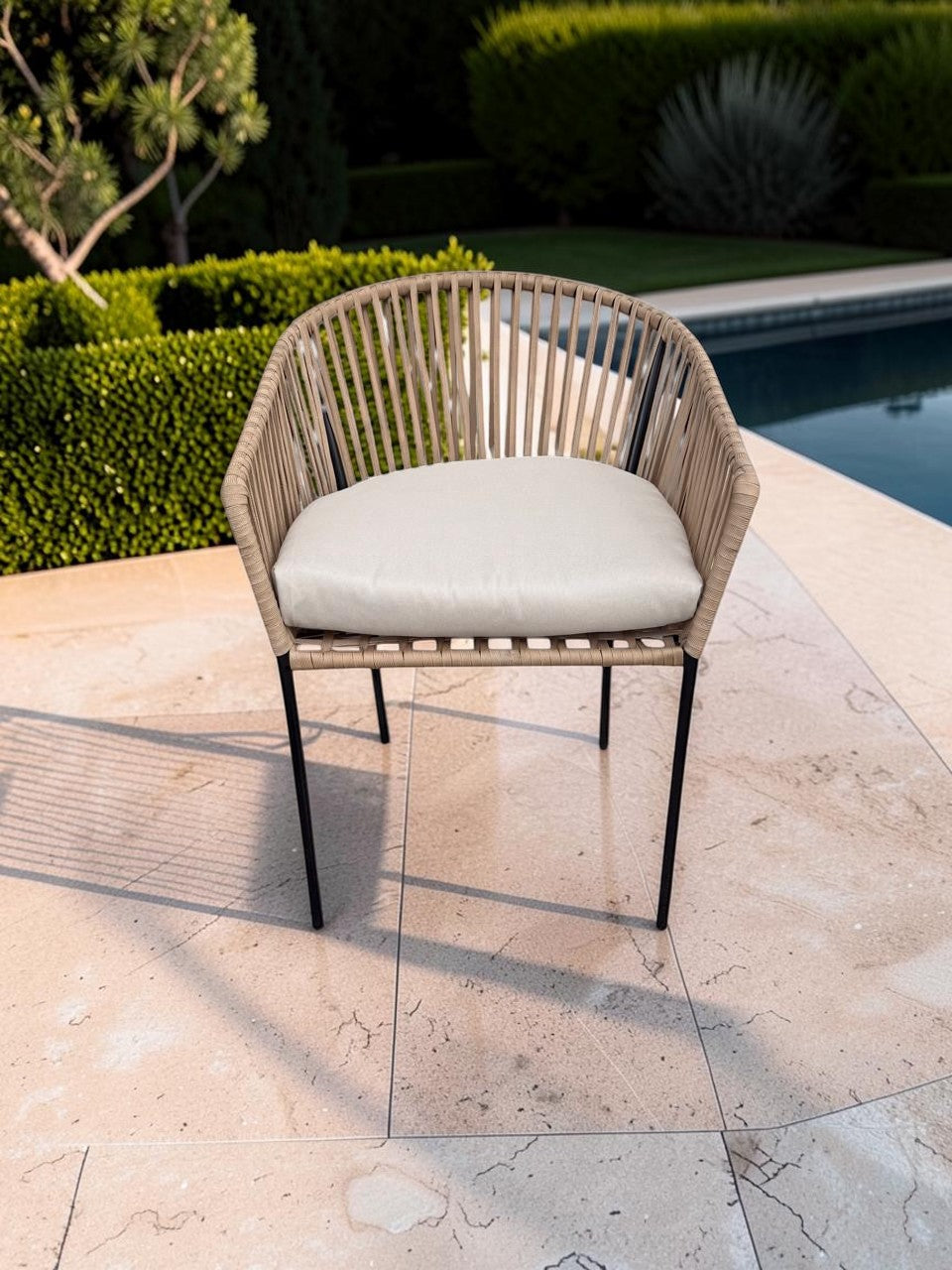 Silla Carreña de CASA GARRIDO Muebles con estructura de metal negro, respaldo de cuerda beige y cojín blanco exterior