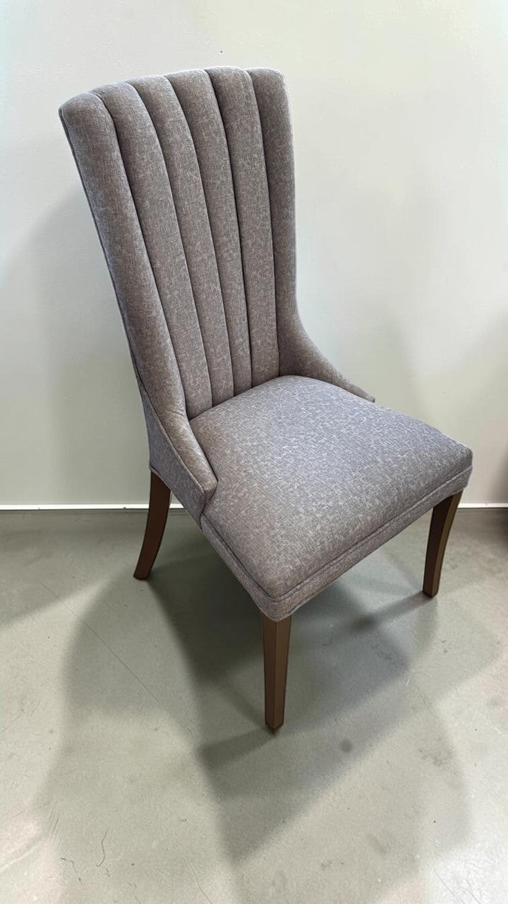 Silla Dusseldorf de CASA GARRIDO Muebles con tapizado gris, respaldo acanalado ergonómico y patas de madera oscura.