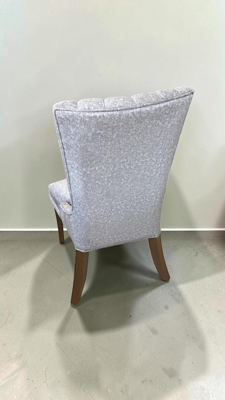 Silla Dusseldorf de CASA GARRIDO Muebles con tapizado gris texturizado y patas de madera oscura en vista trasera