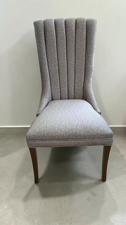 Silla Dusseldorf de CASA GARRIDO Muebles con tapizado gris texturizado, respaldo acanalado y patas de madera oscura.