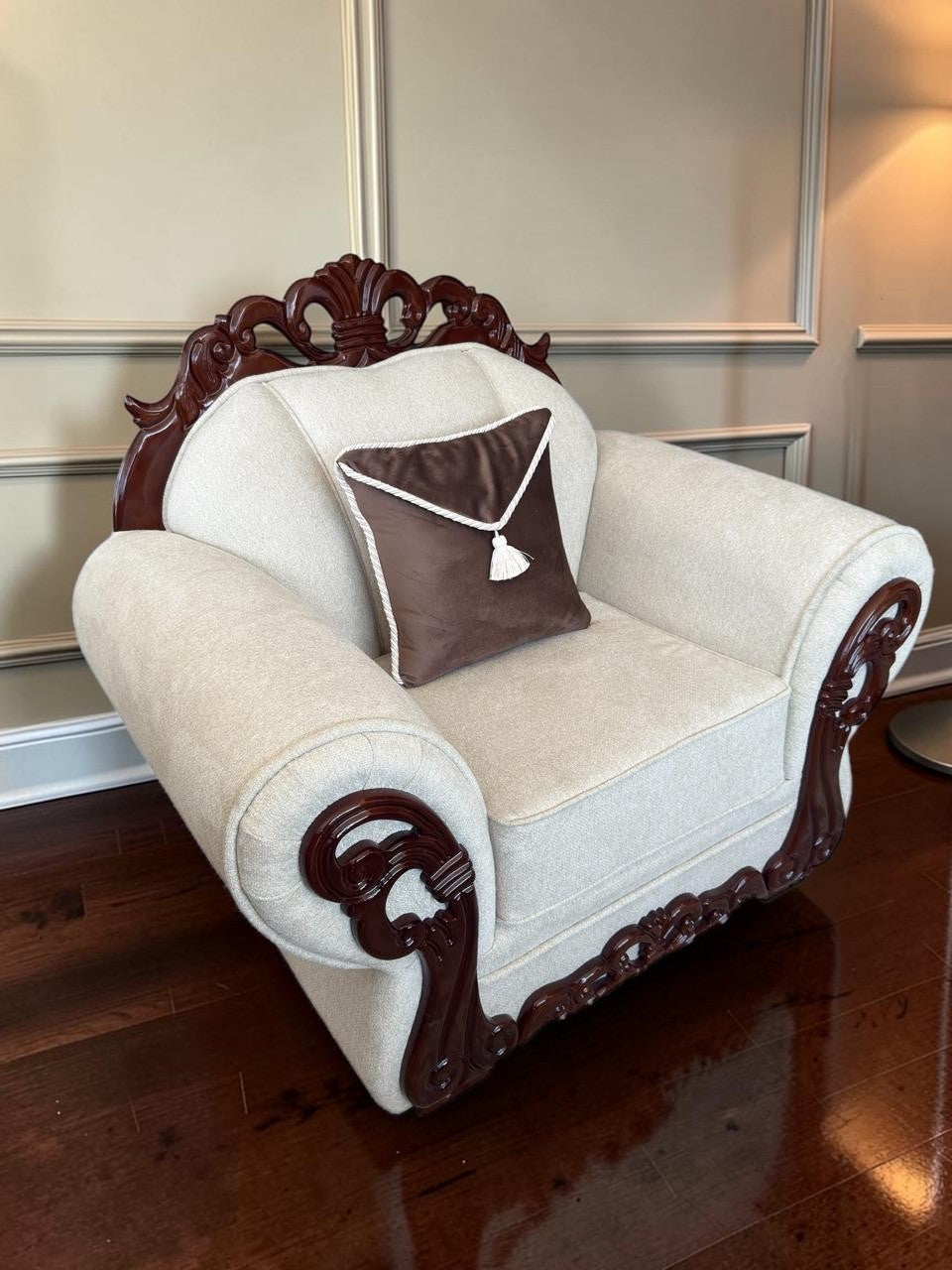 Sillón clásico CASA GARRIDO Muebles modelo Carey con tapizado beige, estructura de madera tallada y cojín marrón.