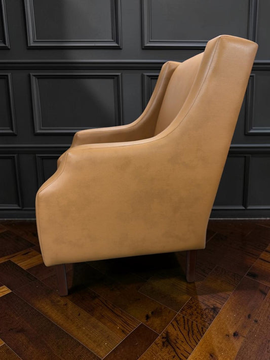 Sillón Kabul de CASA GARRIDO Muebles tapizado en cuero color beige con diseño de respaldo alto y patas de madera