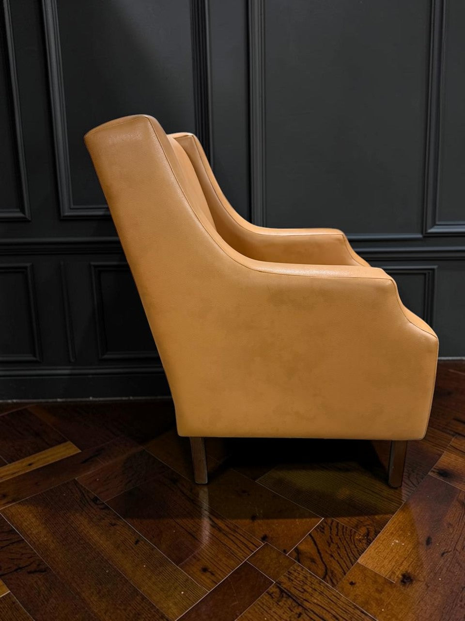Sillón Kabul de CASA GARRIDO Muebles en cuero color camel con diseño moderno y patas de madera vista lateral