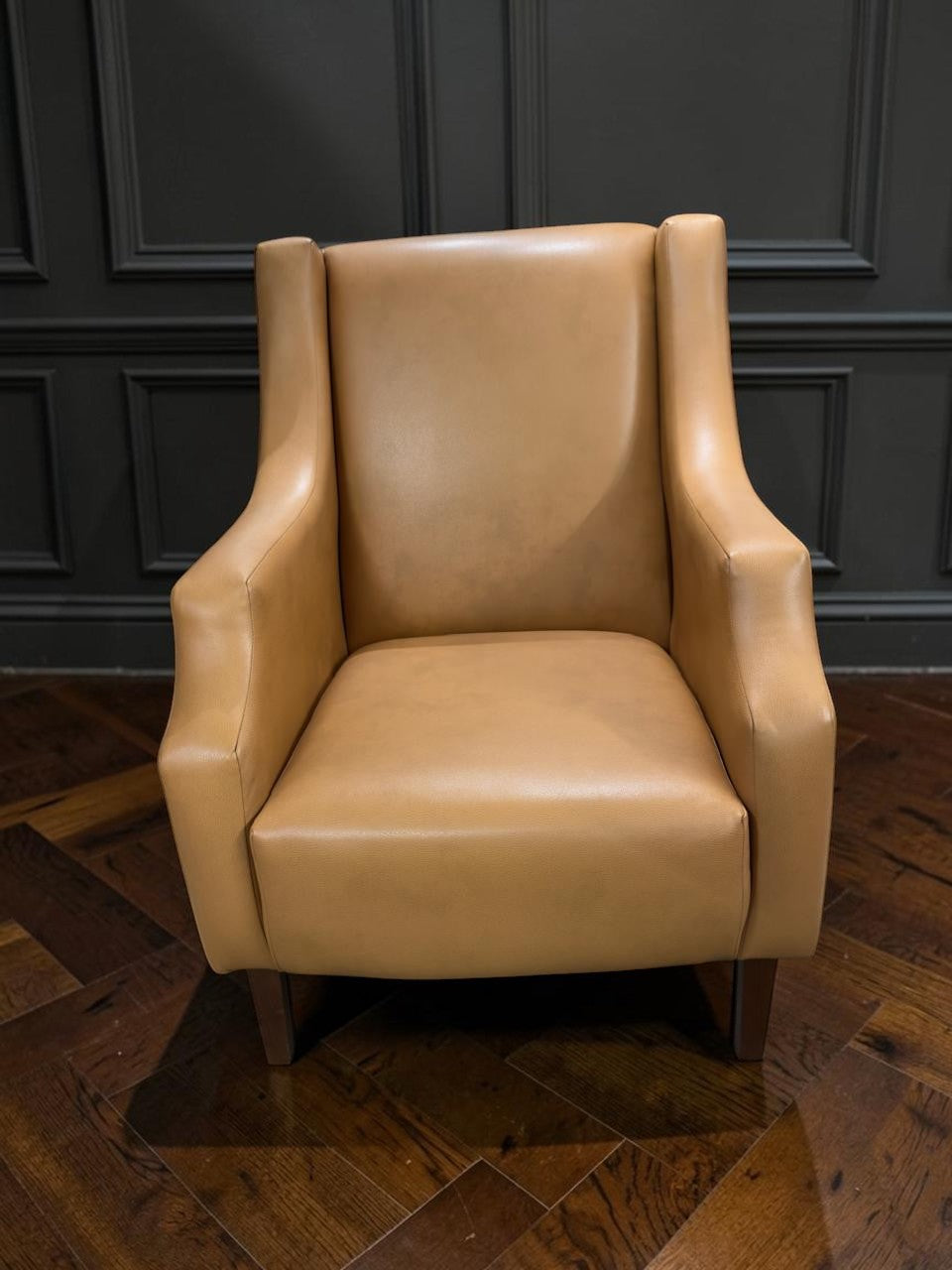 Sillón Kabul de CASA GARRIDO Muebles tapizado en cuero color beige con diseño de respaldo alto y patas de madera