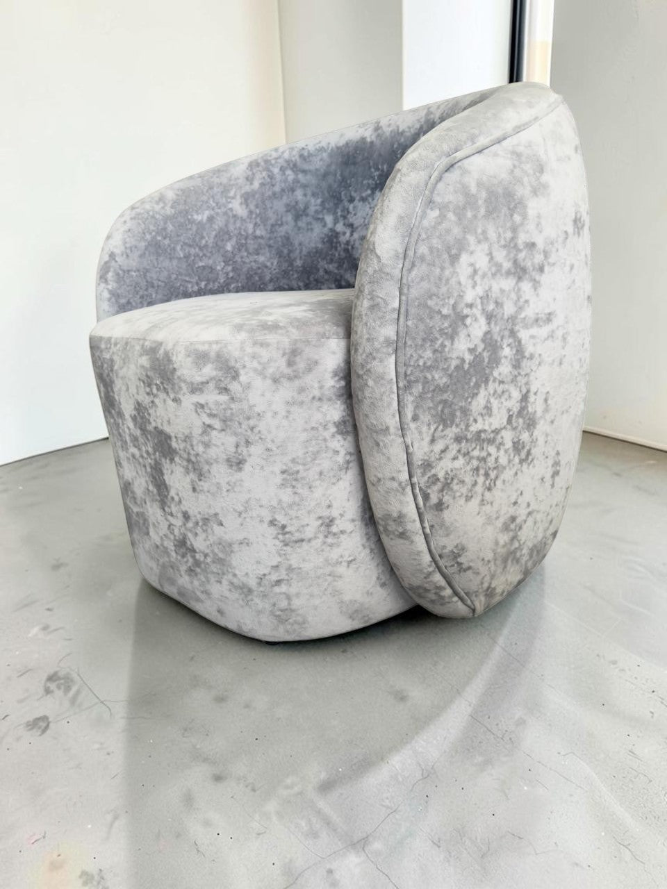 Sillón Kabul de CASA GARRIDO Muebles con diseño curvo contemporáneo y tapizado de terciopelo gris texturizado