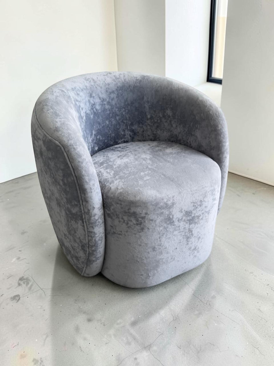 Sillón Kabul de CASA GARRIDO Muebles en tela gris aterciopelada con diseño curvo contemporáneo y estructura robusta.