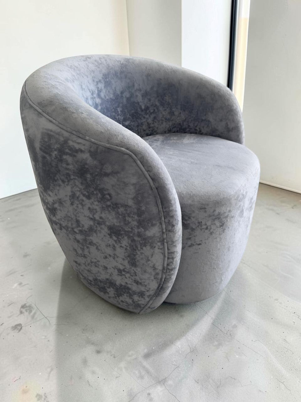 Sillón Kabul de CASA GARRIDO Muebles con diseño curvo contemporáneo y tapizado en tela gris de textura suave