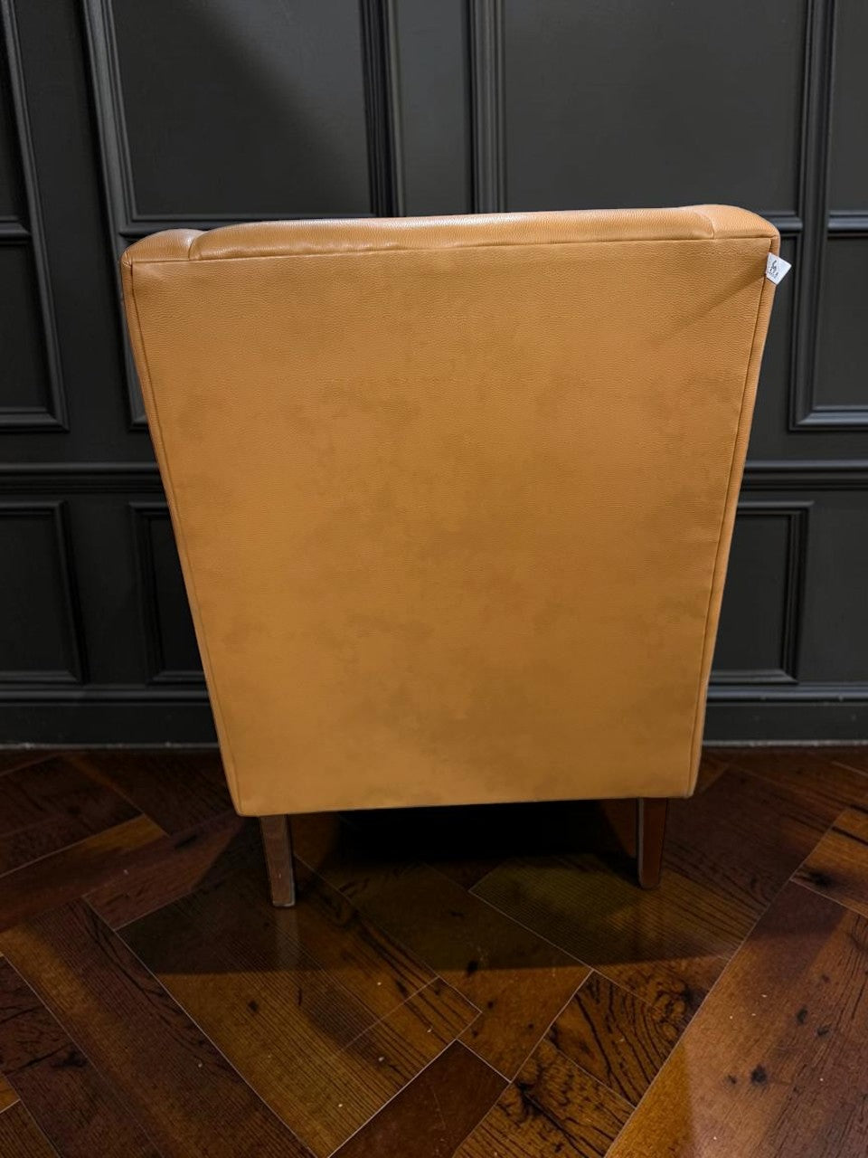 Vista trasera del sillón Kabul de CASA GARRIDO Muebles tapizado en cuero color camel con patas de madera