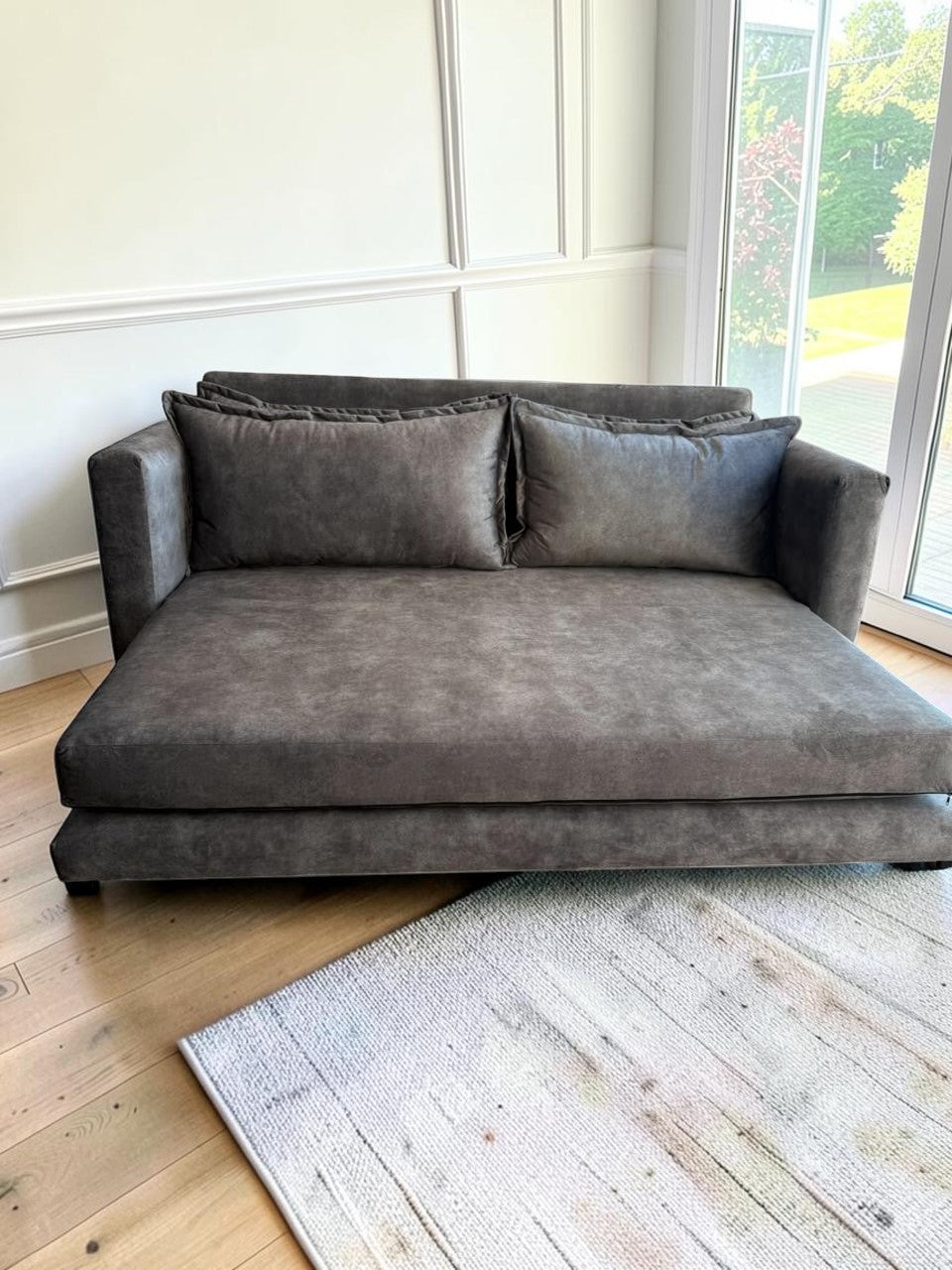 Sofa cama Bangkok de CASA GARRIDO Muebles en color gris con diseño moderno y tapizado suave en una sala de estar.