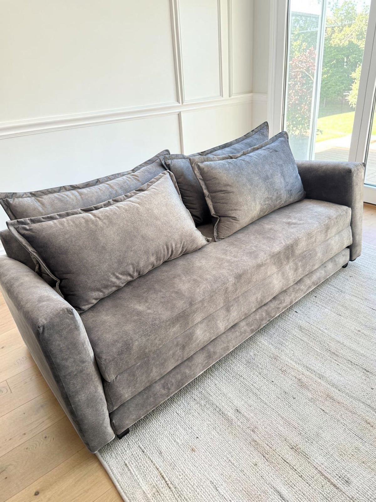 Sofá cama Bangkok de CASA GARRIDO Muebles en tela gris aterciopelada con cojines de respaldo, diseño moderno y elegante.