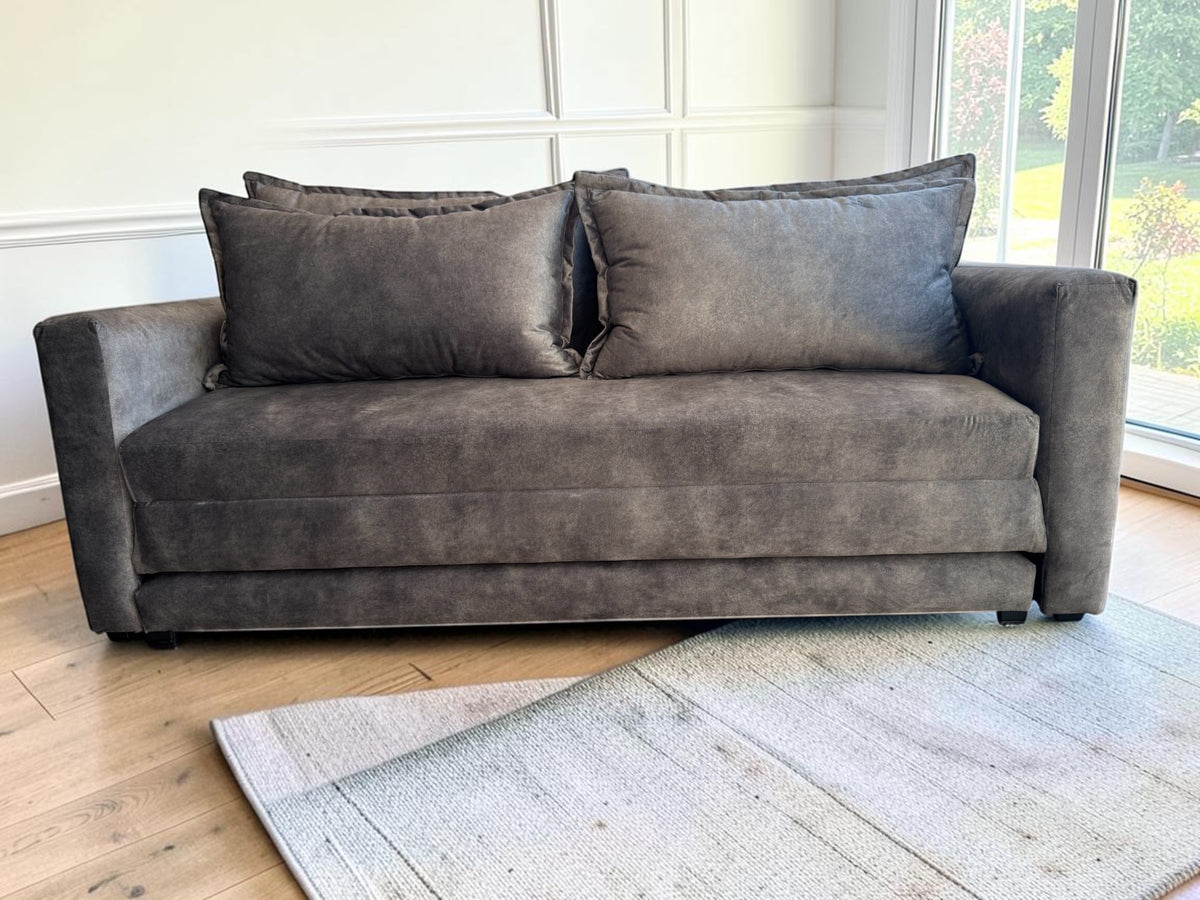 Sofá cama Bangkok de CASA GARRIDO Muebles en color gris oscuro con diseño moderno y cojines amplios en sala de estar