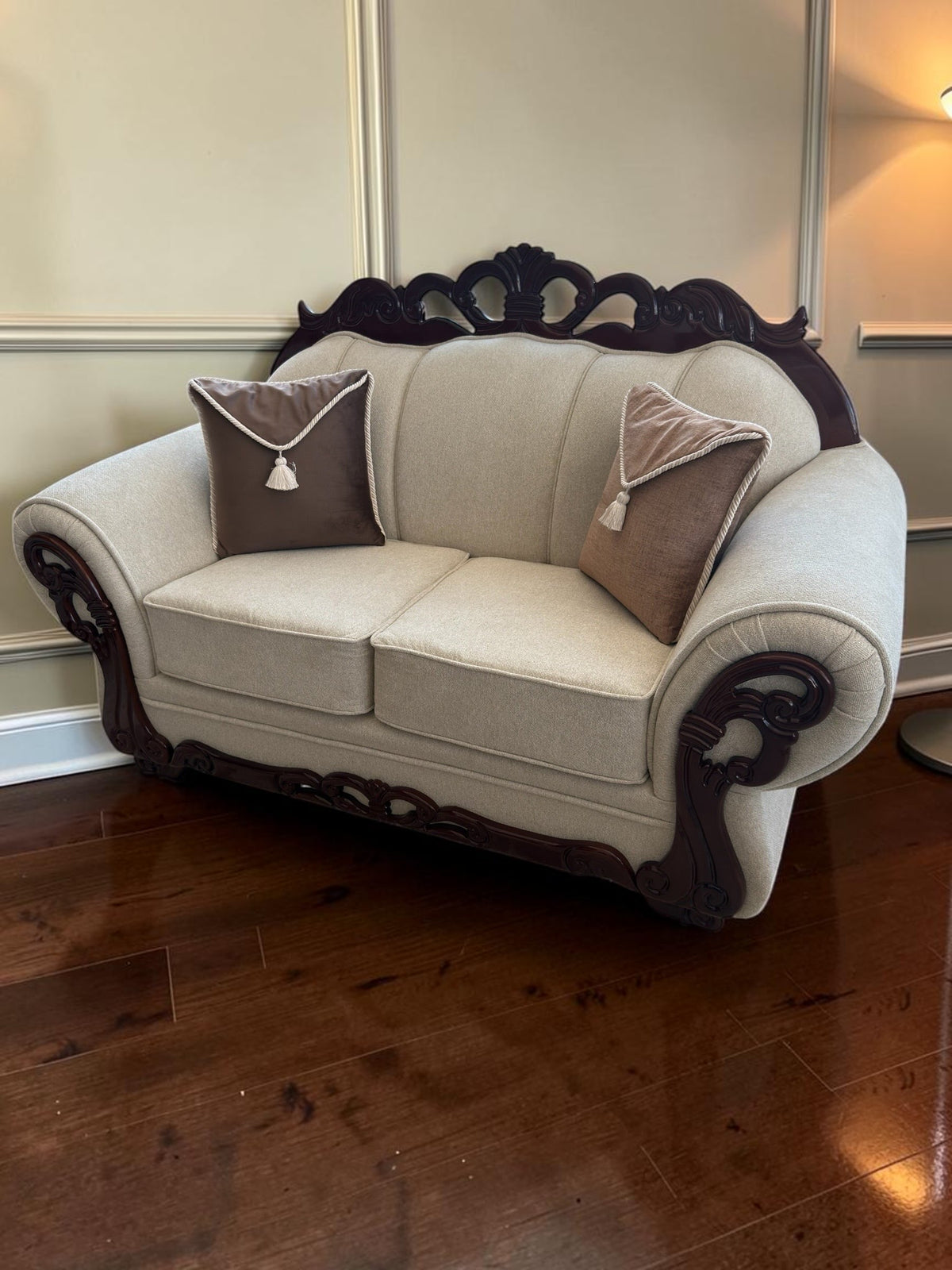 Sofá de dos plazas CASA GARRIDO Muebles modelo Carey con tapizado beige, estructura de madera oscura y dos cojines.