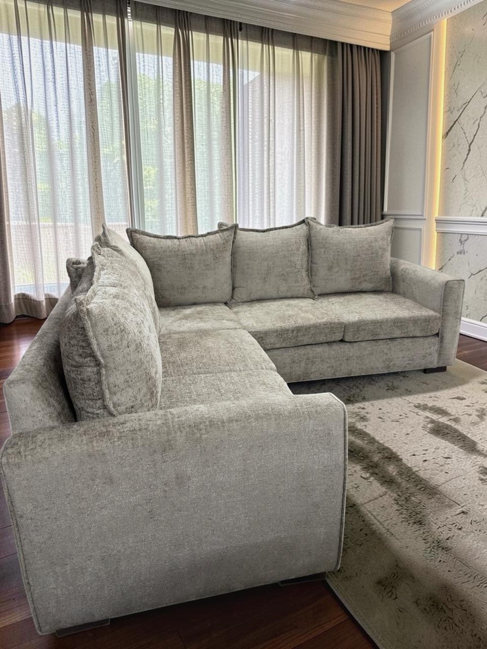 Sofá en L modelo Croacia de CASA GARRIDO Muebles en tela gris texturizada con cojines de respaldo en sala moderna